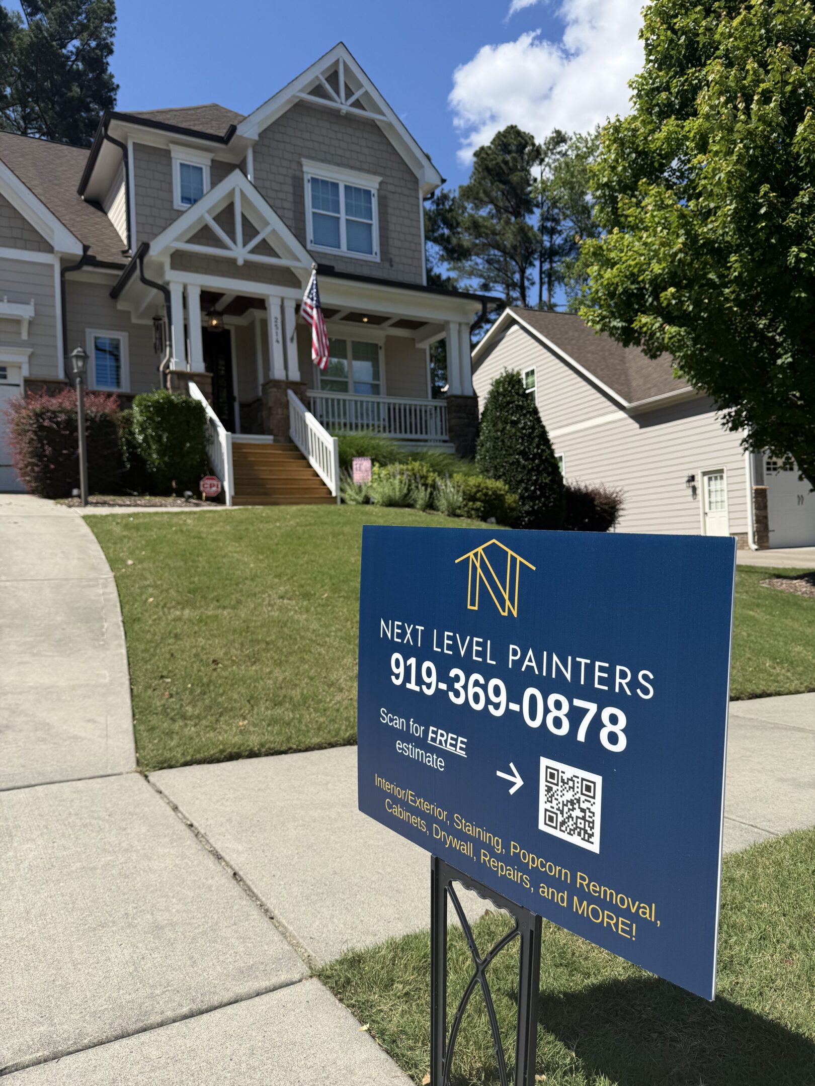 House with a real estate sign for painters in the front yard.
