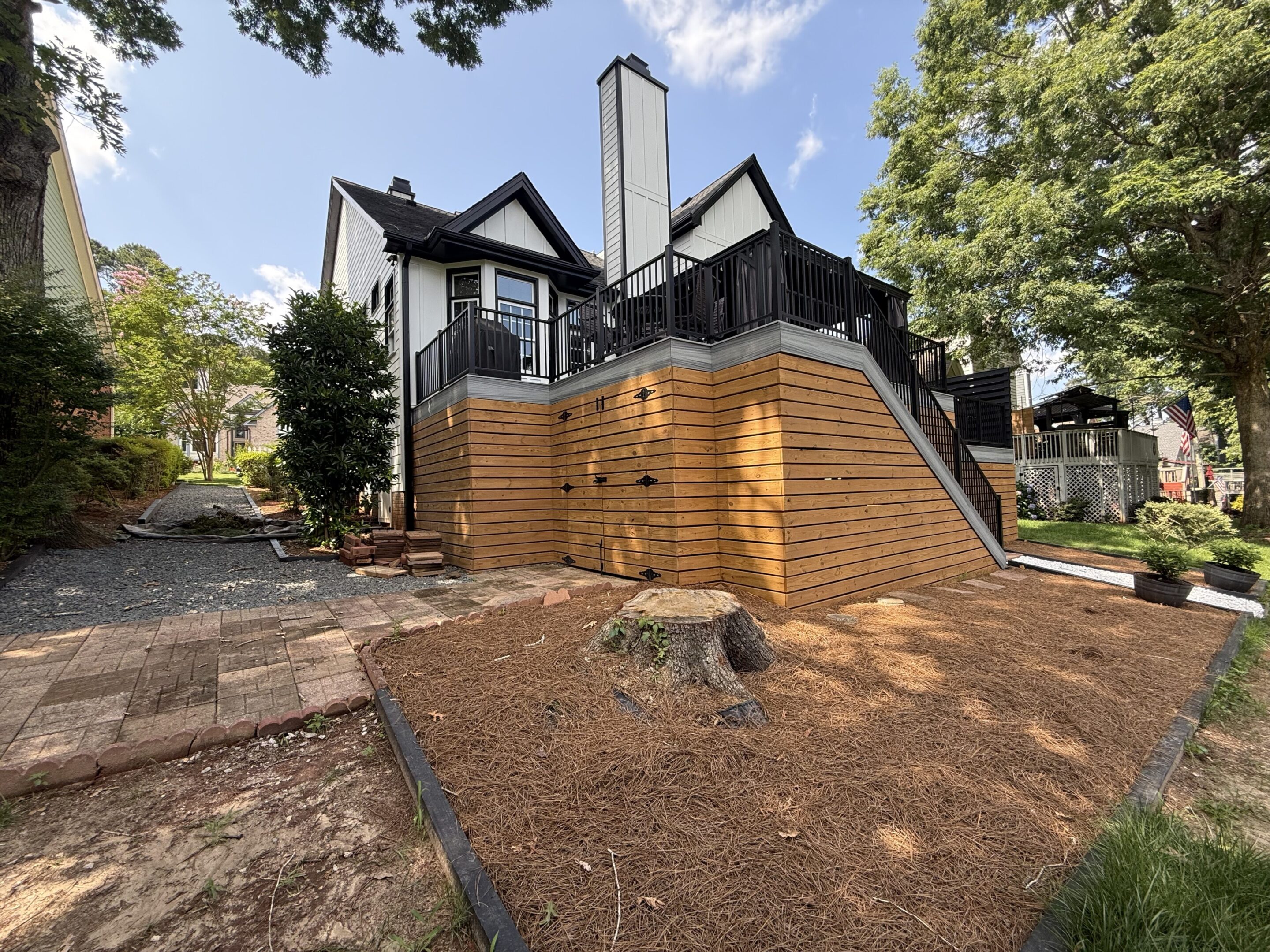 A unique house with wooden and brick exterior surrounded by trees.