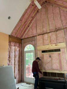 Man inspecting wall insulation installation in a home under construction.