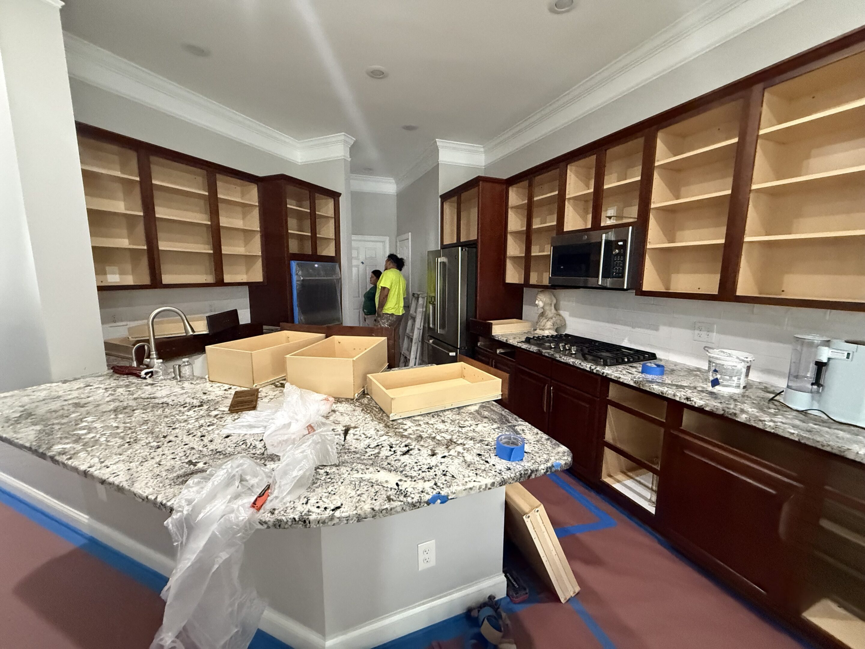 Kitchen under renovation with new cabinets and granite countertops.