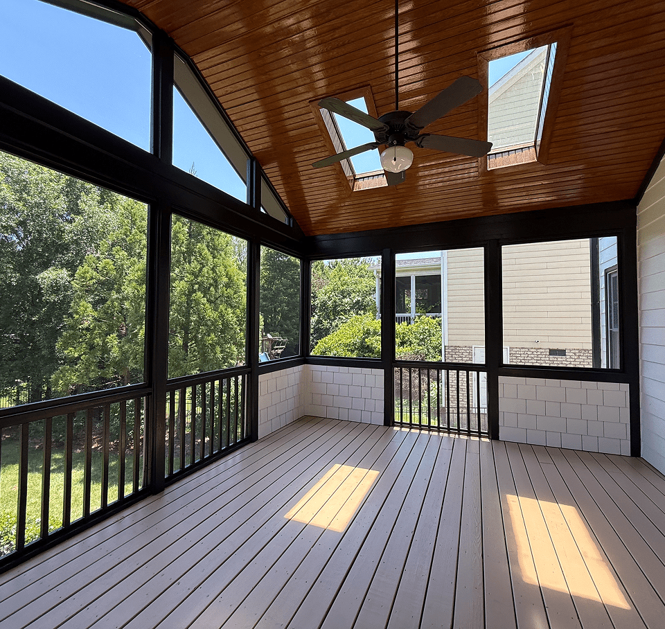 Bright screened-in porch with wooden ceiling and light flooring.