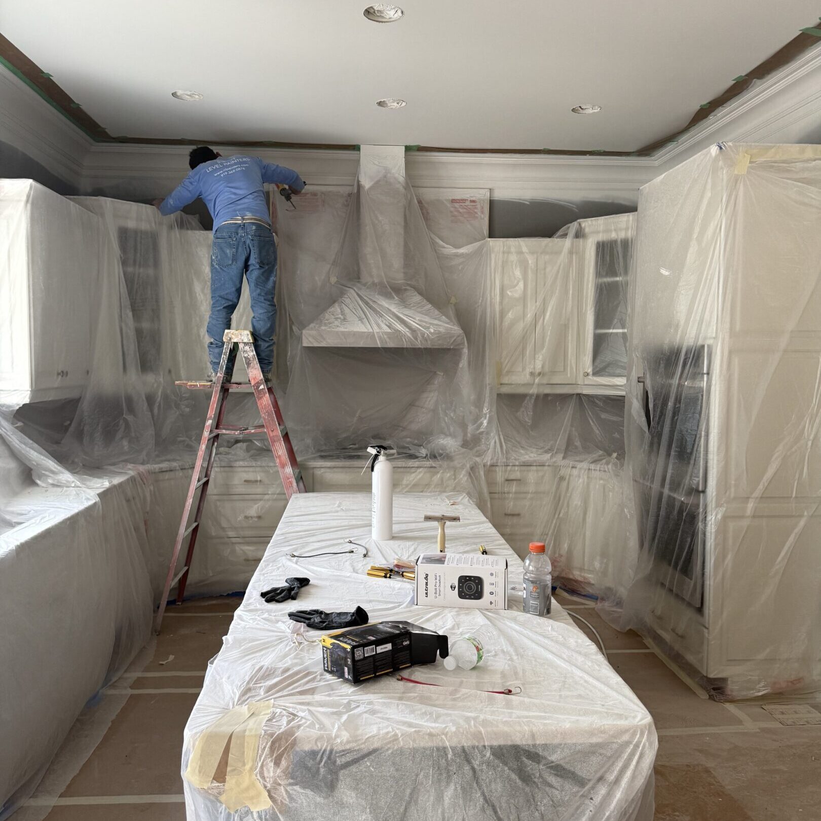Worker installing cabinets in a kitchen under renovation.